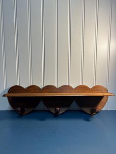 a wooden shelf sitting on top of a blue floor next to a white striped wall