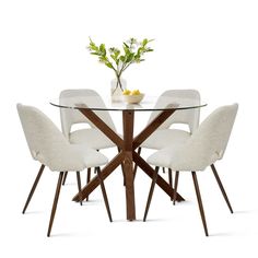 a glass table with four chairs and a vase filled with flowers on top of it