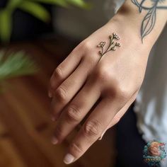 a woman's hand with a flower tattoo on it