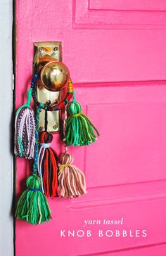 a pink door with some tassels hanging on it