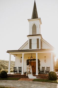 a bride and groom standing in front of a church with the sun shining on them