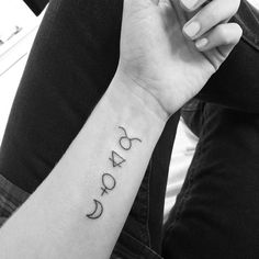 a woman's wrist with the word yoga tattooed on her left arm and an arrow in the middle