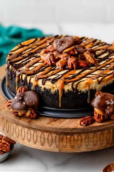 a chocolate cheesecake topped with pecans and caramel drizzle