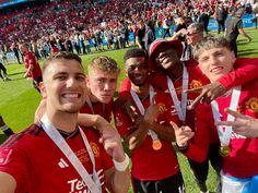 the soccer team is posing for a photo with their gold medals in front of an audience