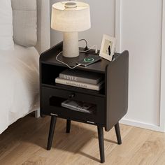 a night stand with a lamp and books on it