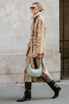 a woman walking down the street carrying a bag