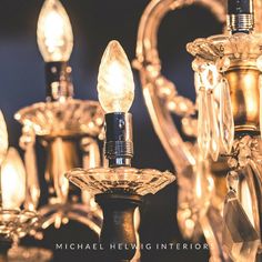 a chandelier with several lights hanging from it's sides and the words michael helwig interiors