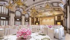 the banquet hall is decorated with white linens and pink flowers