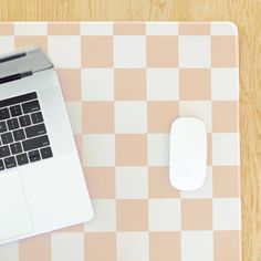 a laptop computer sitting on top of a desk next to a white mouse and keyboard