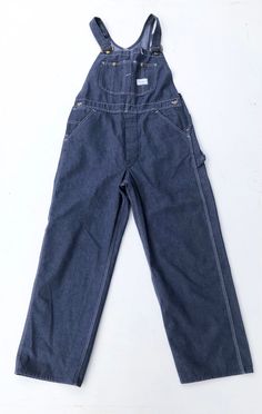 "1970s Sears Tradewear denim overalls have white topstitching throughout, a snap chest pocket, a button fly, hip pockets, and back patch pockets with a carpenter's loop and utility pocket. The overalls have button closures at the hips, and adjustable straps. 50/50 cotton polyester. Condition Excellent. Measurements Chest 15\" (not doubled) Waist 36\" Hip 40\" Rise 13\" Inseam 29\" Length 59\"" Retro Denim Blue Overalls With Pockets, Vintage Denim Blue Overalls With Pockets, Retro Dark Wash Shortalls With Pockets, Retro Straight Leg Overalls With Pockets, Retro Overall Jeans With Pockets, Retro Denim Overalls With Pockets, Vintage Straight Leg Overalls With Pockets, Lee Denim Jacket, Blue Denim Overalls