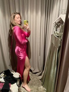 a woman taking a selfie in front of a mirror wearing a pink robe and matching heels