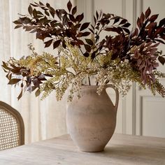 a vase filled with flowers sitting on top of a wooden table