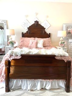 a large bed sitting in a bedroom next to a dresser and mirror with pictures on the wall