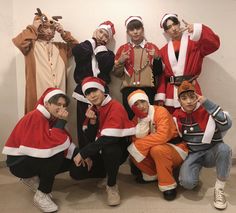 a group of people dressed in costumes posing for a photo with santa clause hats on