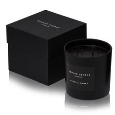 a black candle sitting in front of a box