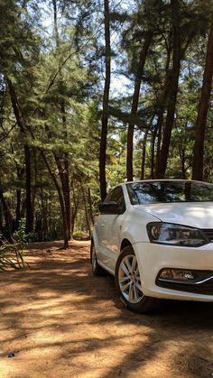 a white car is parked in the woods