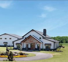 a large white house sitting on top of a lush green field