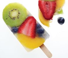 two popsicles with fruit on them sitting next to each other