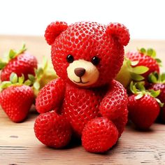 a teddy bear made out of strawberries sitting on a table with other strawberries