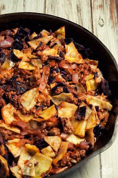 a skillet filled with food sitting on top of a wooden table