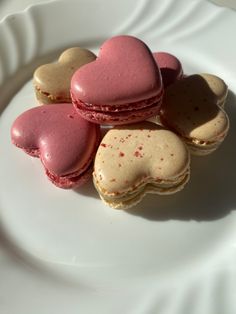 four heart shaped macaroons on a white plate