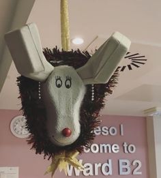 an animal head hanging from the ceiling in front of a sign that says esso i come to ward b2