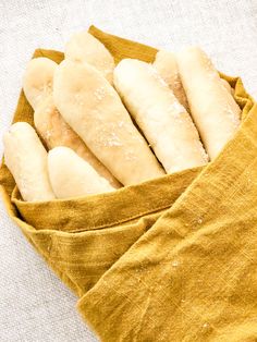 some bread sticks are in a cloth bag