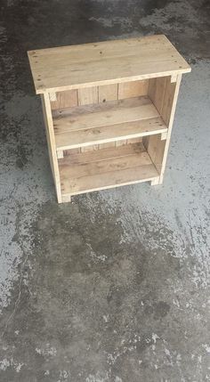 a wooden shelf sitting on top of a cement floor