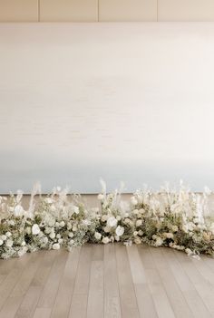 an arrangement of white flowers on a wooden floor