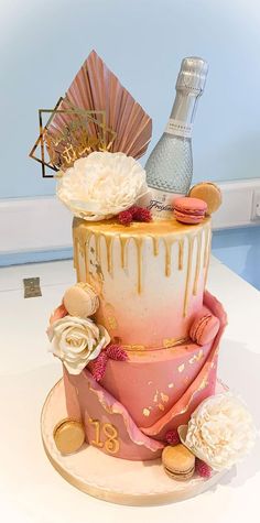 a three tiered cake decorated with flowers and champagne