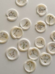 a bunch of buttons that are on a white surface with some flowers in the middle