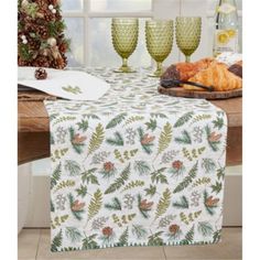 a table topped with plates and glasses next to a christmas tree on top of a wooden table