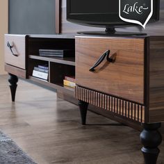 an entertainment center with a large tv on it's stand and a sign that says lake