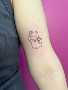 a woman with a cat tattoo on her arm and the other arm is holding a small kitten