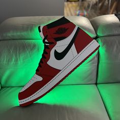 a pair of red and white sneakers sitting on top of a green light up couch