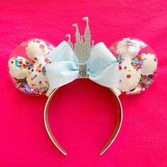 a minnie mouse head with a blue bow and sprinkles on it