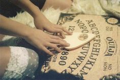 a woman is sitting on the floor with her hand on a wooden plaque that reads,