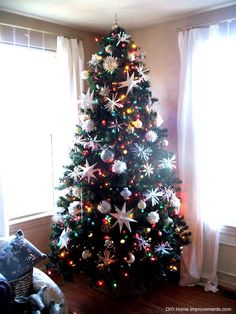 a decorated christmas tree in the corner of a living room with bright lights on it