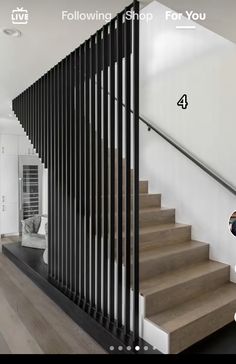 the stairs in this house are made of wood and metal, with black slats on each handrail