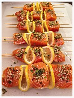 salmon and lemon skewers with herbs on them