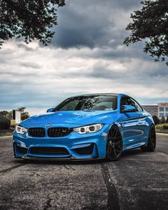 a blue bmw is parked on the street