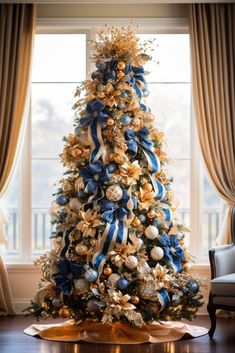 a decorated christmas tree in front of a window with blue and gold decorations on it