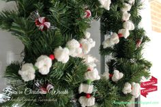 a christmas wreath made out of crocheted cotton balls and candy canes hanging from a door