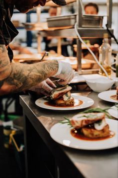 a man preparing food on top of white plates