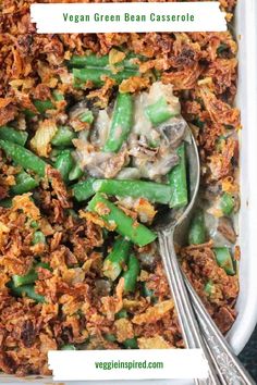 green bean casserole in a white dish with two spoons on the side