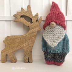 a knitted santa claus and a wooden reindeer ornament hanging on a wall