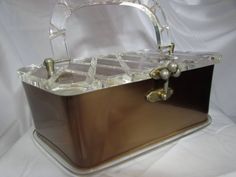 a brown and white purse sitting on top of a white cloth covered tablecloth,