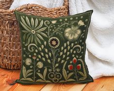 a green pillow sitting on top of a wooden floor next to a wicker basket