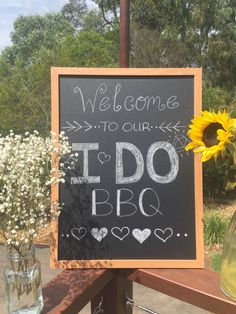 a chalkboard sign that says welcome to our loved bbq and sunflowers