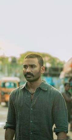 a man with a mustache standing in the street